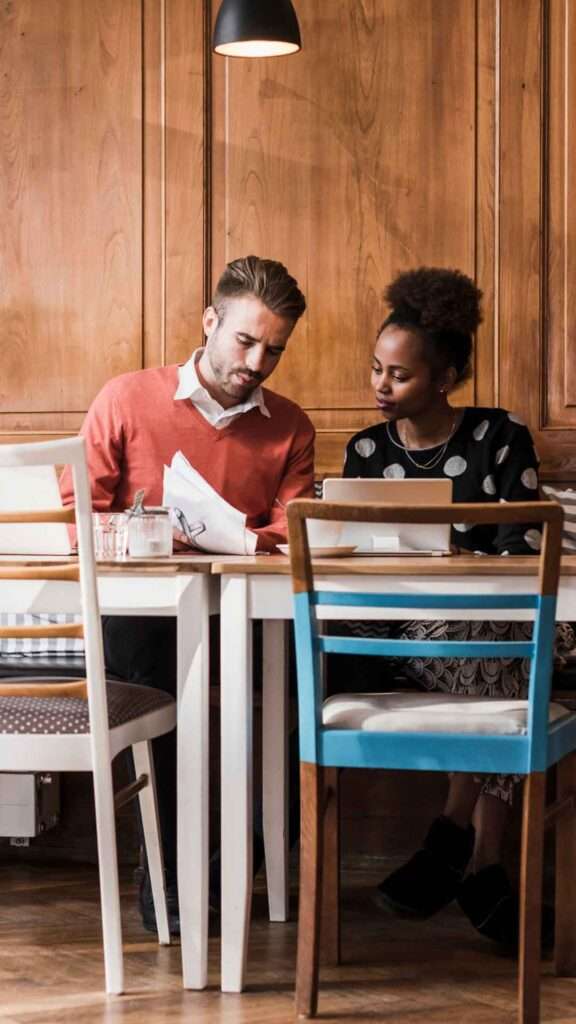 Man and woman reviewing investments at a table